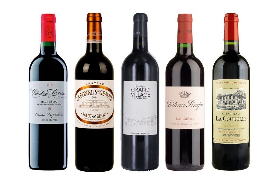 Five bottles of red wine from various châteaux, standing in a row on a white background.