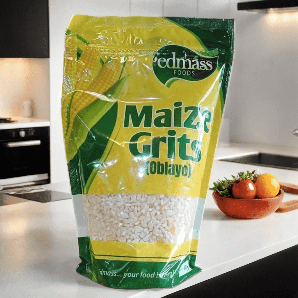 Bag of maize grits on a kitchen counter with a bowl of tomatoes in the background.